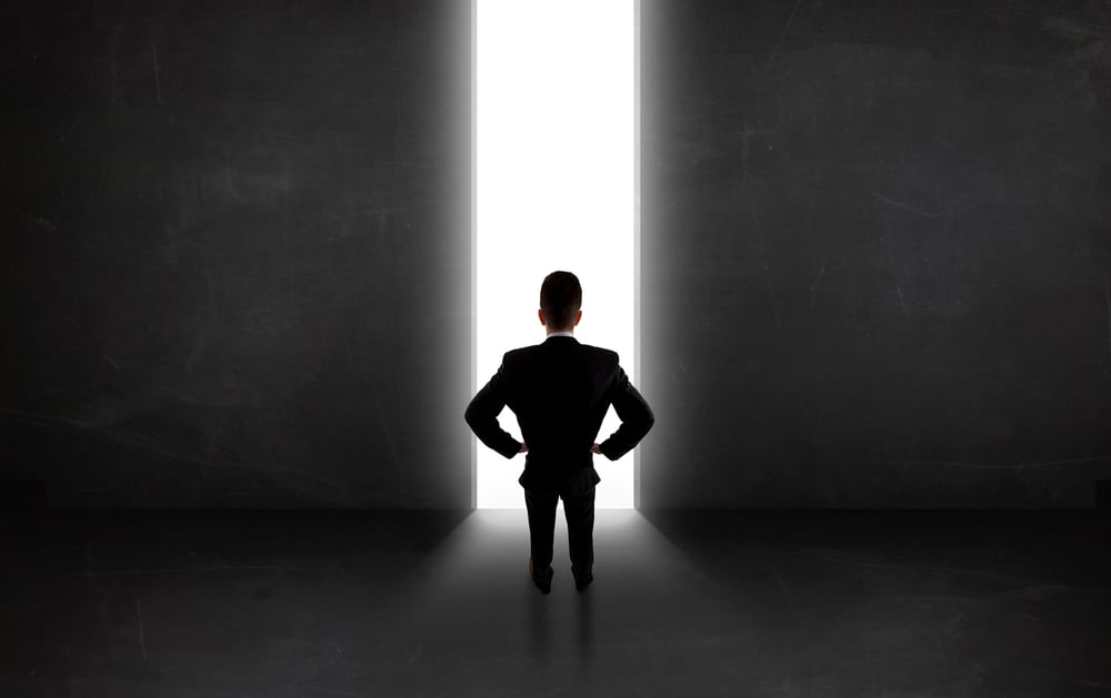 Business person looking at wall with light tunnel opening concept-1